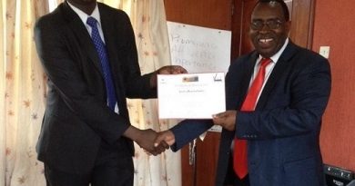 Jared Oundo receives a certificate from FBS Kariuki Senior careers officer moi University